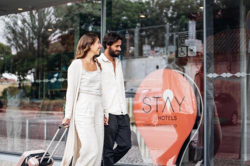 a man and a woman standing in front of a store window at Stay Hotel Lisboa Aeroporto in Lisbon