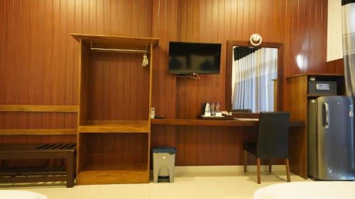 a room with a desk and a television and a chair at Randiya Sea View Hotel in Mirissa