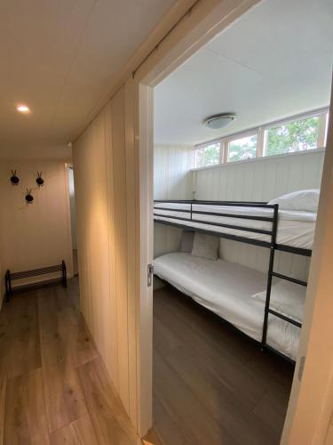 a room with two bunk beds and a hallway at 'T Veluwse Boshuus chalet 44 in Hattemerbroek