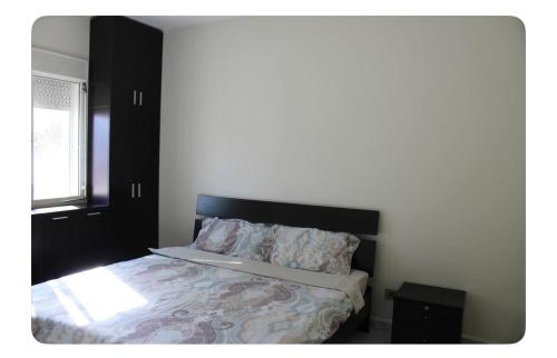 a bedroom with a bed with a black headboard at Luxury Apartment Koneytra 2 Bedrooms - 2 Baths in Bekfaya
