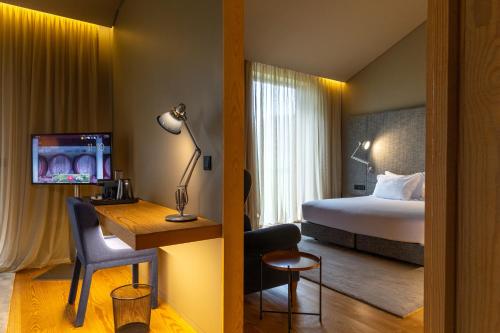 a hotel room with a bed and a desk with a desk at Monverde - Wine Experience Hotel - by Unlock Hotels in Amarante