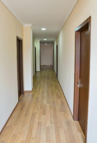 an empty hallway with wooden floors and doors at Just Inn Kutaisi in Kutaisi