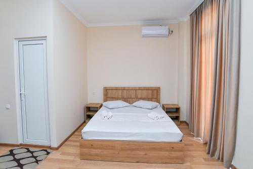 a bedroom with a bed with white sheets and a window at Just Inn Kutaisi in Kutaisi