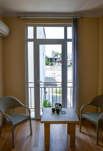 a coffee table in front of a large window at Just Inn Kutaisi in Kutaisi