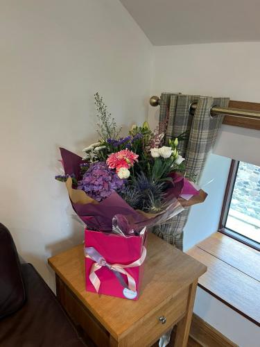 a bouquet of flowers sitting on top of a table at Stewards Granary in Cornhill-on-tweed