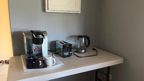 a counter with a coffee maker and coffee cups on it at Big band house in Burnaby