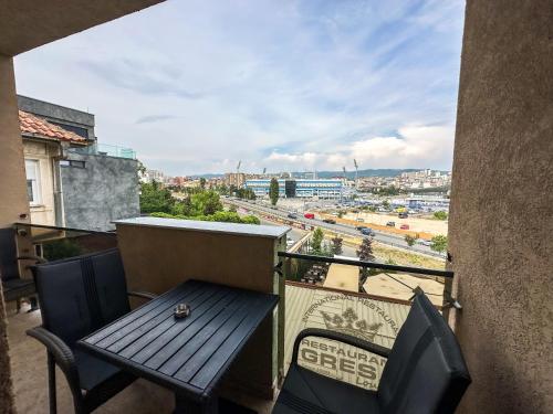 a balcony with a table and chairs and a view at Grand Apartments Prishtina in Pristina