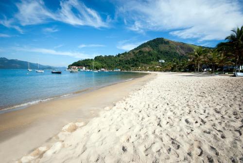 a sandy beach with boats in the water at Portogalo Suite Hotel in Angra dos Reis
