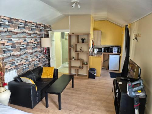 - un salon avec un canapé noir et un mur en briques dans l'établissement 17A DB Airbnb, à Wexford