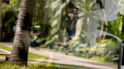a man and a woman standing next to a tree at Shintana Saya La Maison in Siem Reap