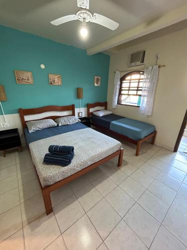 a bedroom with two beds and a window at Pousada Brisa da Praia in Arraial do Cabo