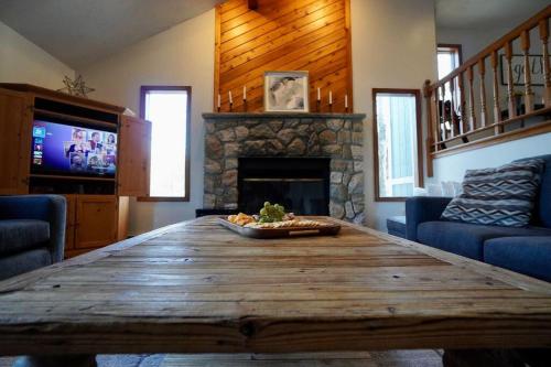 a large wooden table in a living room with a fireplace at Big Blue Lake House complete with Game Room in Long Pond