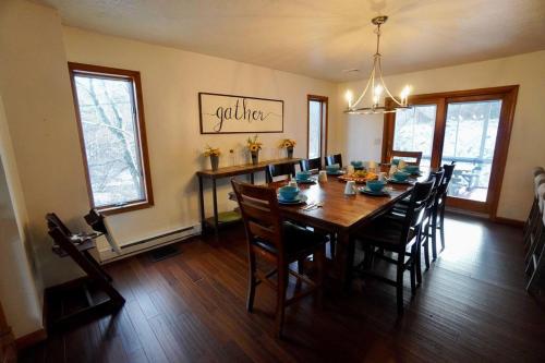 a dining room with a wooden table and chairs at Big Blue Lake House complete with Game Room in Long Pond