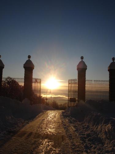 a fence with the sun setting behind it at Santuario di Oropa in Biella