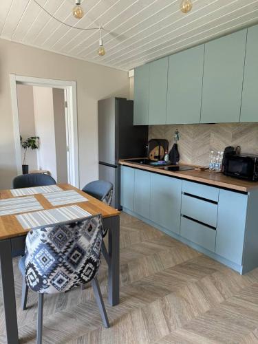 a kitchen with blue cabinets and a wooden table at Grey apartments in Slavske