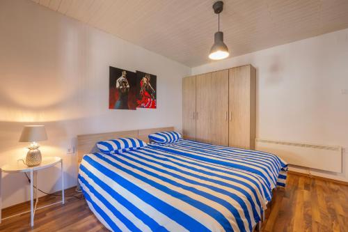 a bedroom with a blue and white striped bed at Apartment Masa - FREE bikes in Premantura
