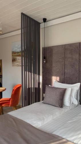 a bedroom with a bed and a orange chair at Grey apartments in Slavske