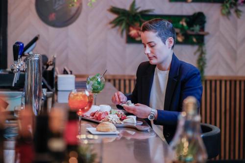 a man sitting at a table with a plate of food at Novotel Luxembourg Centre in Luxembourg