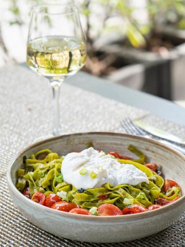 a bowl of pasta with a glass of wine at Novotel Luxembourg Centre in Luxembourg