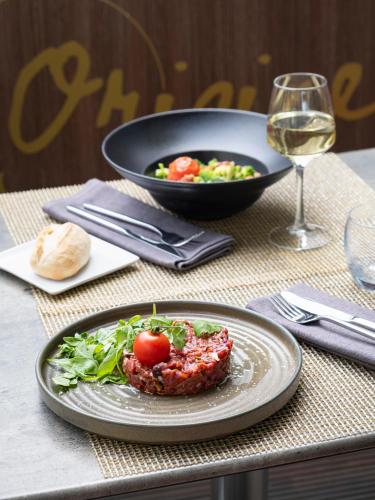 a table with a plate of food and a bowl of salad at Novotel Luxembourg Centre in Luxembourg