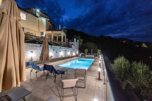 a patio with chairs and a swimming pool at night at Portico Rodriguez Abatemarco in Abatemarco
