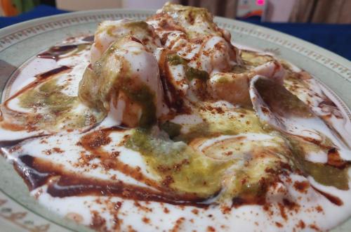 a plate of food with two slices of pizza at HOTEL JOGI GUEST HOUSE 15min walk Golden temple10 min walk Railway Station and Bus stand in Amritsar