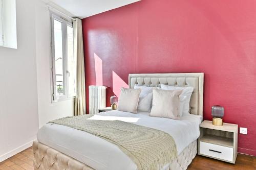 - une chambre avec un mur rose et un lit dans l'établissement Appartement Rose Moderne Proche de la capitale II, à Gagny
