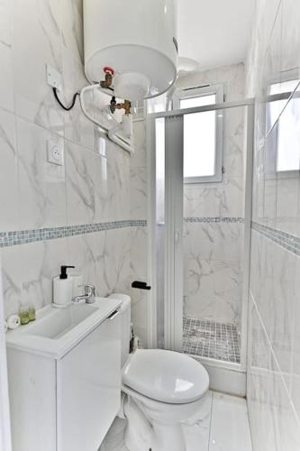 une salle de bain blanche avec toilettes et douche dans l'établissement Appartement Rose Moderne Proche de la capitale II, à Gagny