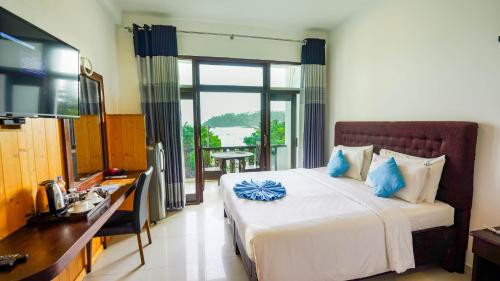 a bedroom with a bed and a desk and a television at Randiya Sea View Hotel in Mirissa