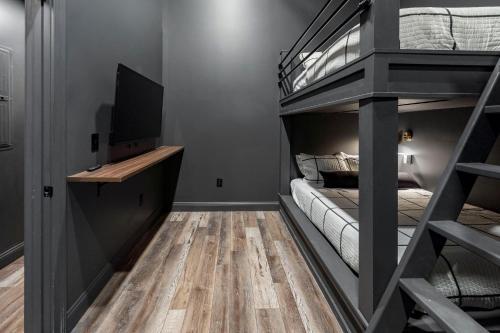 a small room with a bunk bed and a television at Downtown Derby Delight in Louisville