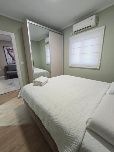 a bedroom with a large white bed with a window at GK apartments Ballerina in Bat Yam