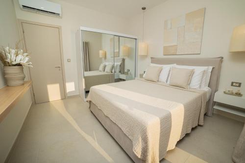 a bedroom with a large bed with white sheets and pillows at Vouros Villages - Villa in Masouri