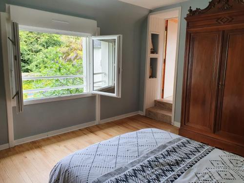 une chambre avec un lit et une grande fenêtre dans l'établissement Jardin clos et calme, vélos à disposition, plages à 2 kms, à Tréffiagat