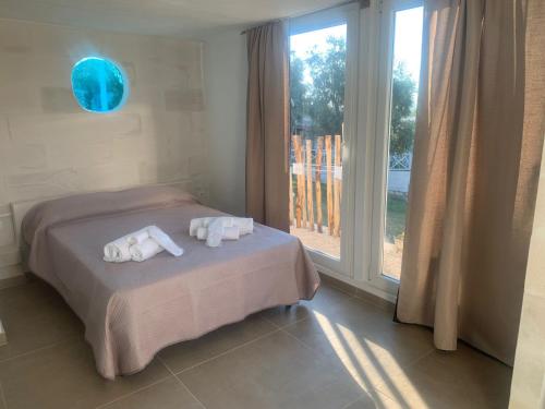 ペスキチにあるTenute le Difenseのベッドと大きな窓のある寝室