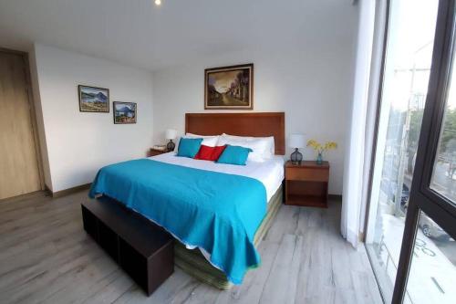 危地马拉DN2A-Great location with patio and pool的卧室里有一张大床，上面铺着蓝色毯子