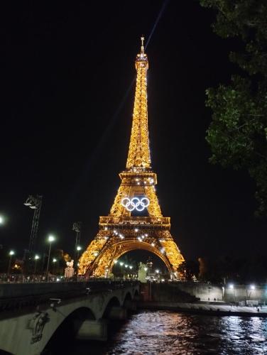 a view of the eiffel tower lit up at night at Amazing location-T3 Near Paris, Parking, Garden in Argenteuil