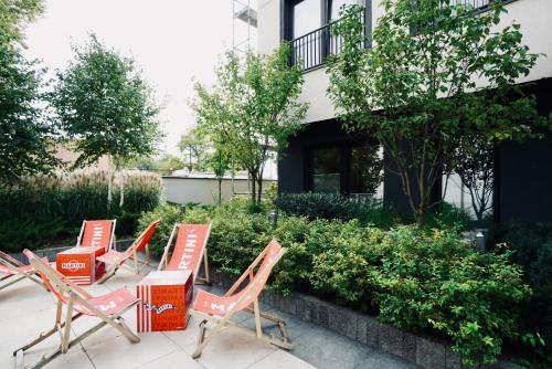 a group of chairs sitting in front of a building at BK Aparthotel Praga - National Stadium - Comfortable Apartment for 4 people in Warsaw