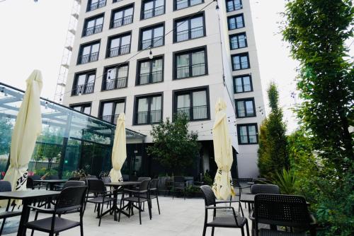 an outdoor patio with tables and chairs and a building at BK Aparthotel Praga - National Stadium - Comfortable Apartment for 4 people in Warsaw