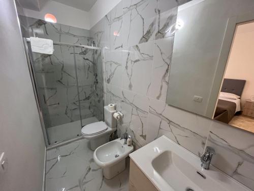 a bathroom with a sink and a toilet and a mirror at Suite Costa Sicana in Siculiana