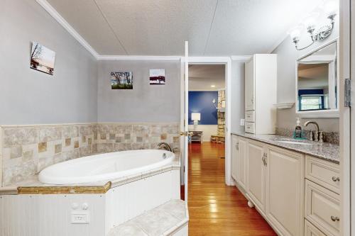 a white bathroom with a tub and a sink at Little River Bend Abode in Mabank