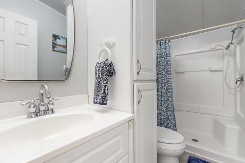 a bathroom with a sink and a toilet and a mirror at Little River Bend Abode in Mabank