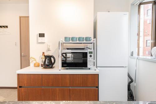 a kitchen with a microwave on top of a counter at Asakusa,Ginza,Ueno,Skytree,Stn&Conv 1min ,Family suite,45 Mins to Airport,Kiyoka Villa 清禾 in Tokyo