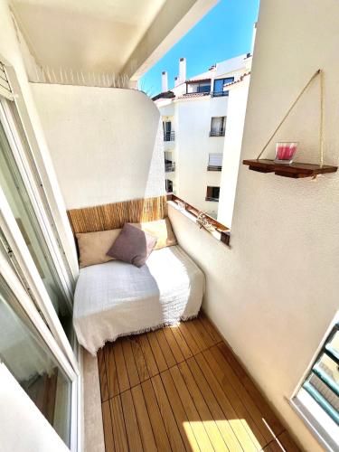 a small balcony with a bed in a room at Mike Beach House in Costa da Caparica
