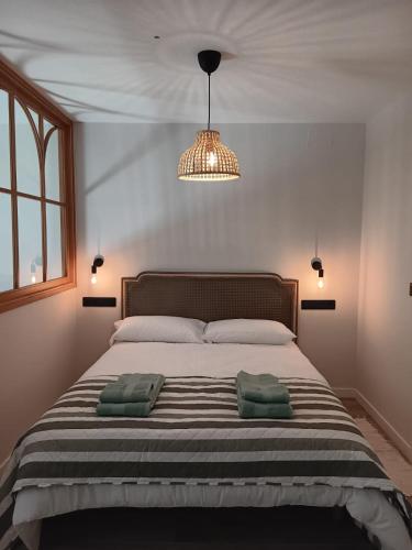 a bedroom with a bed with two green towels on it at Casa Loureiro in Redondela
