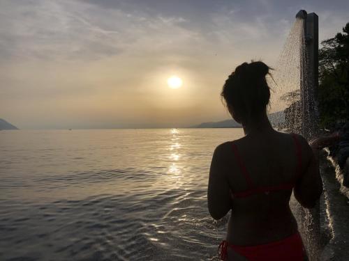 a woman standing in the water watching the sunset at Close to Lake & Chillon Castle, New & Comfortable in Veytaux