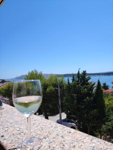a glass of white wine sitting on a table at Studio apartman Dolin in Rab
