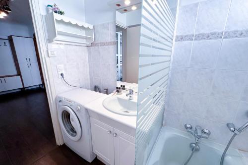 une salle de bain avec une machine à laver et un lavabo dans l'établissement POINCARE 4 - Lumineux, rénové, central et calme à Juan les Pins, à Antibes