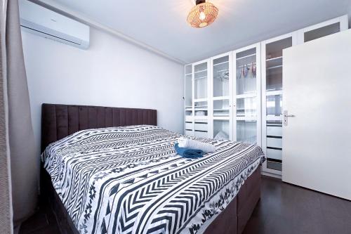 une chambre avec un lit avec une couette noire et blanche dans l'établissement POINCARE 4 - Lumineux, rénové, central et calme à Juan les Pins, à Antibes