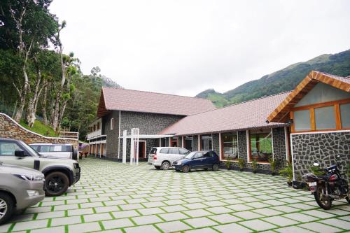 a house with cars parked in a parking lot at The TeaTree Munnar in Suryanelli