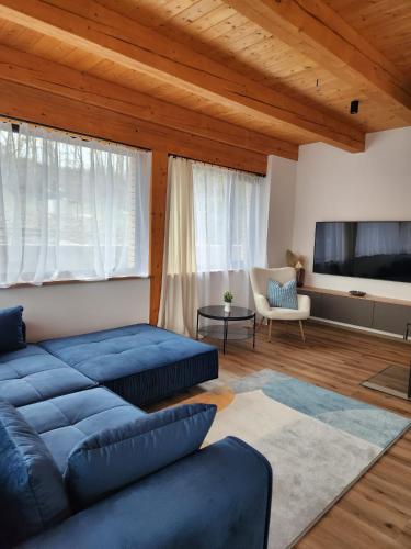 a living room with a blue couch and a flat screen tv at bystřice park Chata Voda in Včelákov